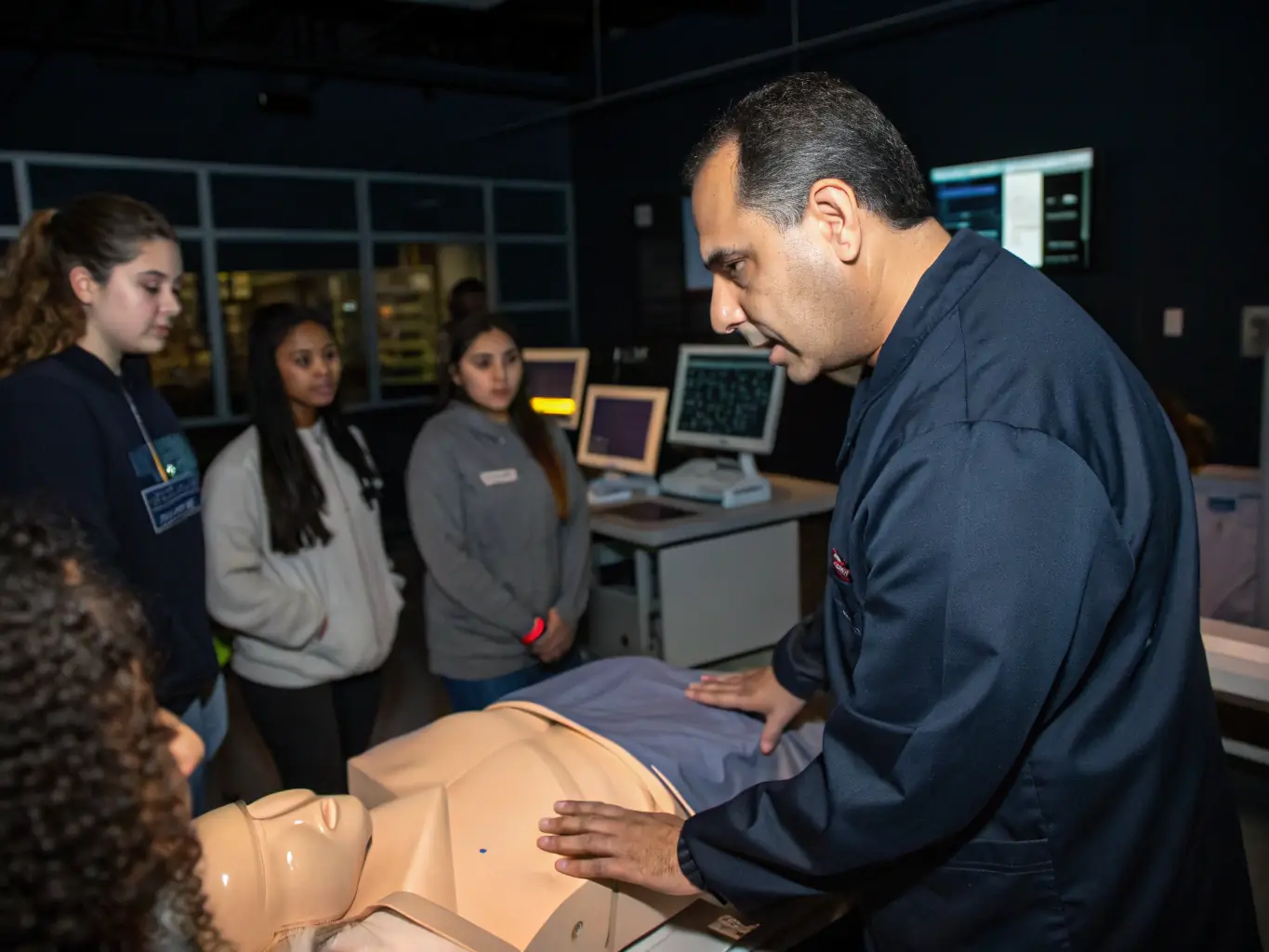 A healthcare professional using a medical simulator with a digital interface, showcasing the realistic and interactive learning environment provided by Peruvian Humanity E.I.R.L.